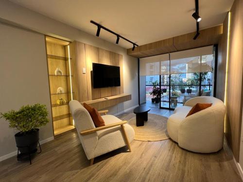 uma sala de estar com duas cadeiras e uma televisão em Departamento Journey em Cusco