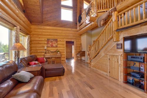 a living room with a couch and a television in a cabin at Legacy Mountain Lodge on 40-Acre Ranch with Views! in Palmer