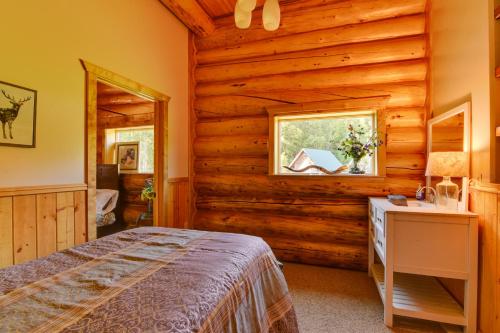 a bedroom with a bed and a window in a log cabin at Legacy Mountain Lodge on 40-Acre Ranch with Views! in Palmer