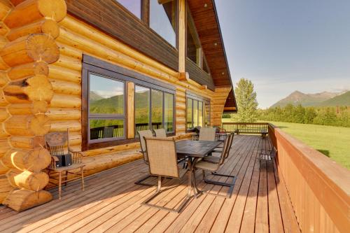 a deck with a table and chairs on a log cabin at Legacy Mountain Lodge on 40-Acre Ranch with Views! in Palmer