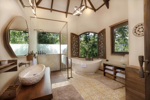 a bathroom with a large tub and a sink at Munduk Mountain Estate in Munduk