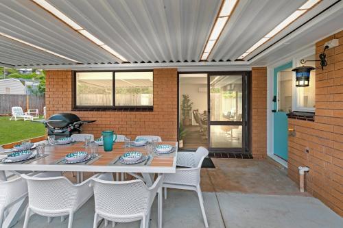 a patio with a table and chairs and a grill at "Julies"-Big fenced yard, nearby beach, Pet friendly in Ocean Grove