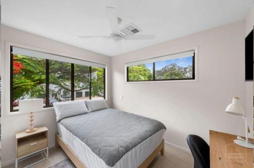 a bedroom with a bed and two windows at Room to rent at the Glasshouse Mountains - Wifi in Brisbane