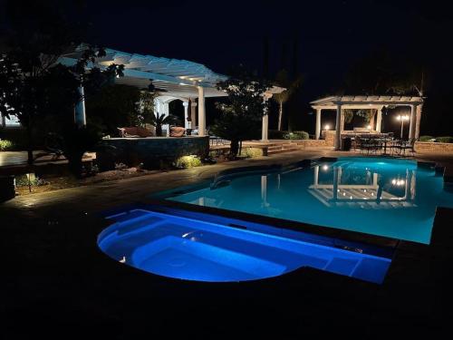 a blue swimming pool in a yard at night at Temecula Wine Country Villa in Temecula