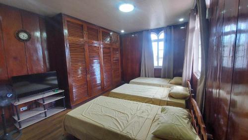1 dormitorio con 2 camas y TV de pantalla plana en Topaz Bed & Breakfast Hotel, en San José
