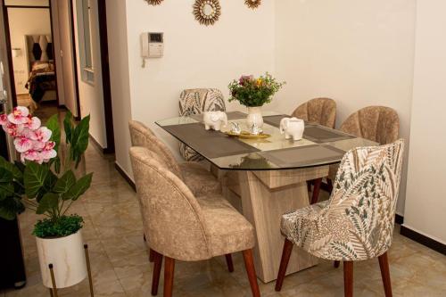 uma sala de jantar com uma mesa de vidro e cadeiras em Departamento Familiar Equipado em Cusco