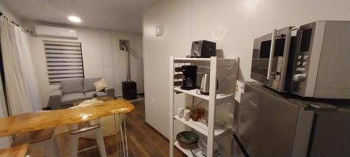 a kitchen with a stainless steel refrigerator and a table at Hojas de Otoño SOLO CON SEÑA in Piriápolis