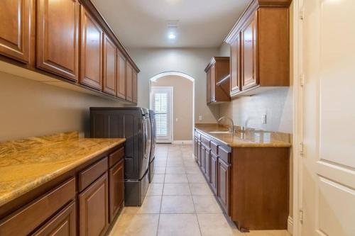 a kitchen with wooden cabinets and a black refrigerator at Temecula Wine Country Villa in Temecula