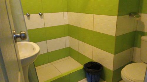 een groene en witte badkamer met een wastafel en een toilet bij HOTEL MAJHAMI in Huancayo