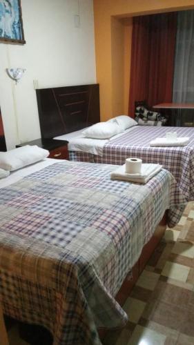 Habitación de hotel con 2 camas y bandeja. en HOTEL MAJHAMI, en Huancayo