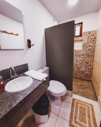 a bathroom with a toilet and a sink and a shower at Pousada Donalu - Ótima Localização in Vale do Capao