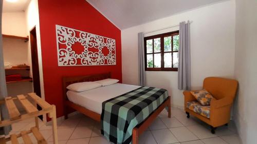 a small bedroom with a bed and a chair at Pousada Donalu - Ótima Localização in Vale do Capao