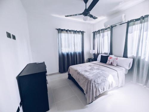 um quarto com uma cama e uma ventoinha de tecto em Apartment in Sosua - 4 Minutes From The Airport em San Felipe de Puerto Plata