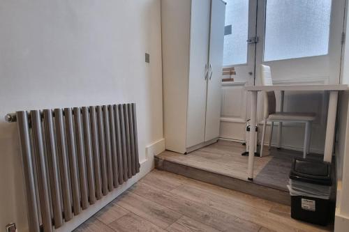 a room with a radiator and a desk and a table at Luxurious 4 Bedroom Entire Flat in King's Cross in London