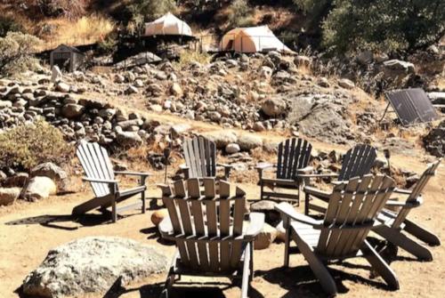 a group of lawn chairs sitting in the sand at Paradise Ranch Inn - Liberated Tent in Three Rivers