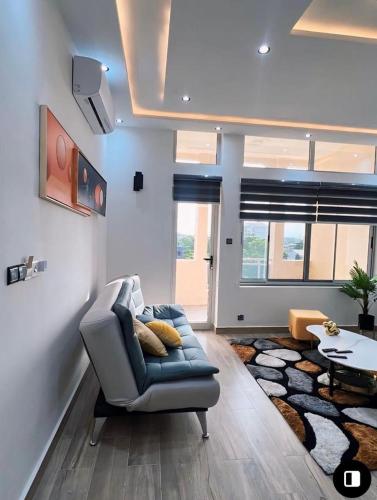 a living room with a blue couch and a rug at Appartement à Cotonou in Cotonou