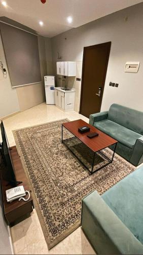 a living room with a couch and a coffee table at أضواء الشرق للشقق الفندقية Adwaa Al Sharq Hotel Apartments in Sīdī Ḩamzah