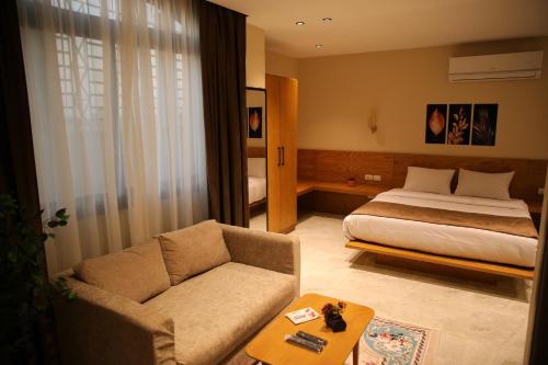 um quarto de hotel com uma cama e um sofá em Regal view Aparthotel no Cairo