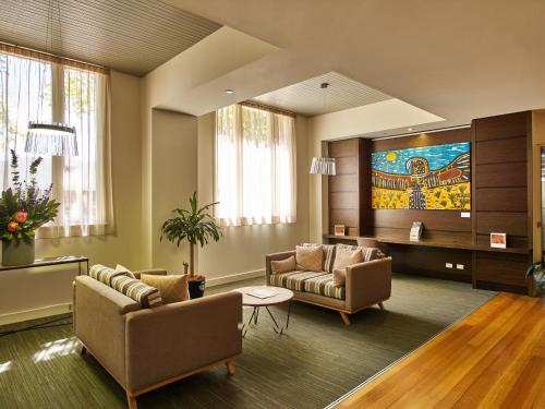 a living room with two couches and a tv at Quest Albury on Townsend in Albury