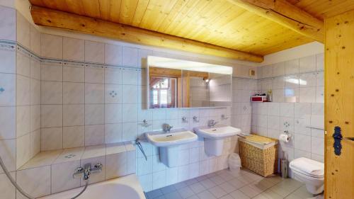ein Badezimmer mit zwei Waschbecken und einem WC in der Unterkunft Abitaziun Chesa Talvo - S-chanf in S-chanf