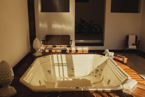 uma banheira num quarto com uma cadeira em Cerejeira Guest House em Campos do Jordão