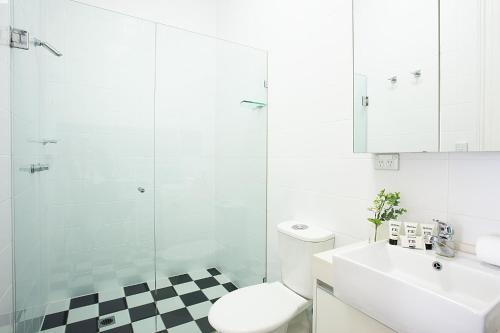 a bathroom with a toilet and a sink and a shower at Spacious Studio With Balcony in Inner-City Glebe in Sydney