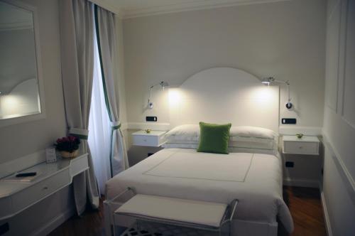 羅馬的住宿－特萊維噴泉套房酒店，一间卧室配有一张带绿色枕头的床