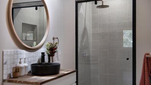 a bathroom with a shower with a sink and a mirror at Kangaroo Creek Estate Daylesford in Glenlyon