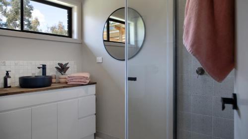 a bathroom with a shower and a sink and a mirror at Kangaroo Creek Estate Daylesford in Glenlyon
