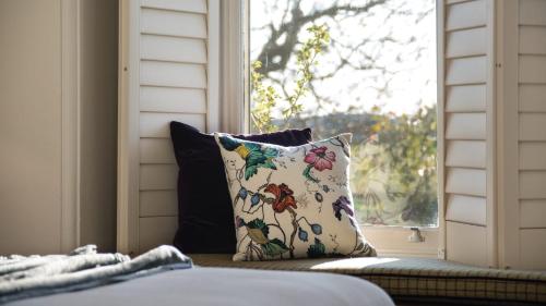 a pillow sitting on a couch in front of a window at The Royal Standard Farm Daylesford in Daylesford