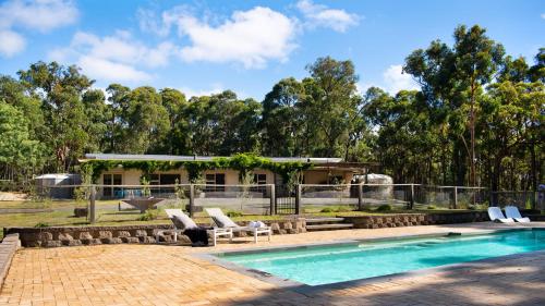 a swimming pool with chairs and a house at Forest Estate Daylesford in Glenlyon