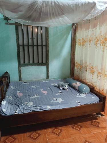 a bed with a stuffed animal laying on it at Đoàn Bình in Diện Biên Phủ