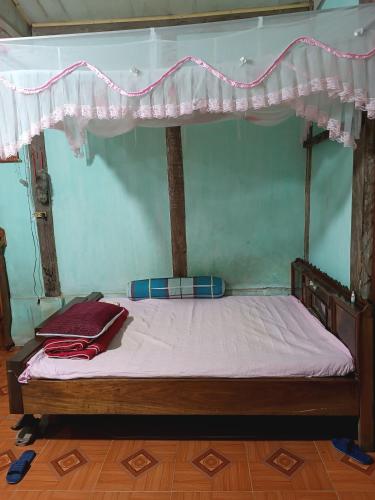 a bed with a canopy in a room at Đoàn Bình in Diện Biên Phủ