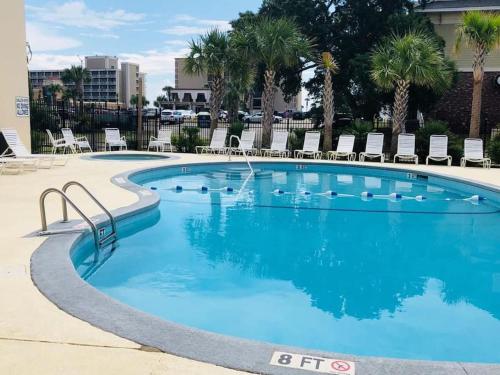 a swimming pool with blue water in a resort at Large Myrtle Beach Condo, Fully Renovated in Myrtle Beach