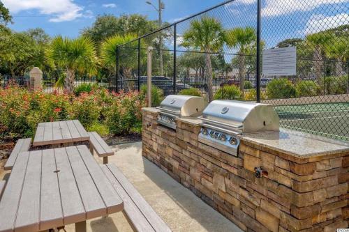 a grill and picnic tables in a park at Large Myrtle Beach Condo, Fully Renovated in Myrtle Beach