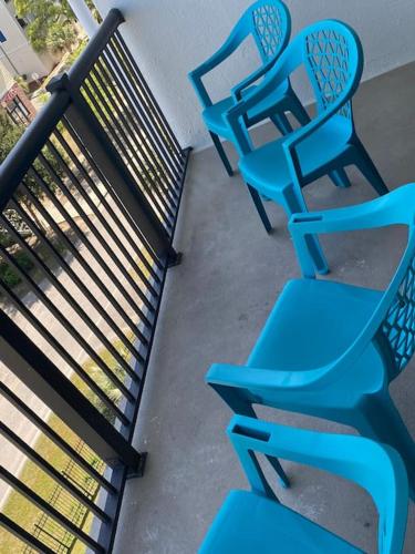 a group of blue chairs sitting next to a fence at Large Myrtle Beach Condo, Fully Renovated in Myrtle Beach