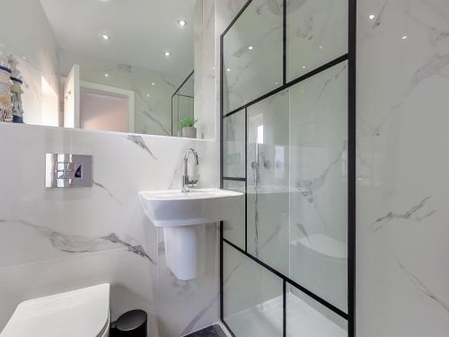 a white bathroom with a sink and a shower at Uk46915 - 2 Orchard Farm Cottage in East Grinstead