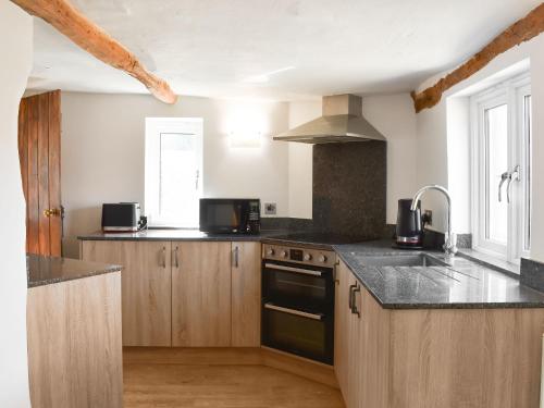 a kitchen with a sink and a stove top oven at Cobblers Retreat in Birley