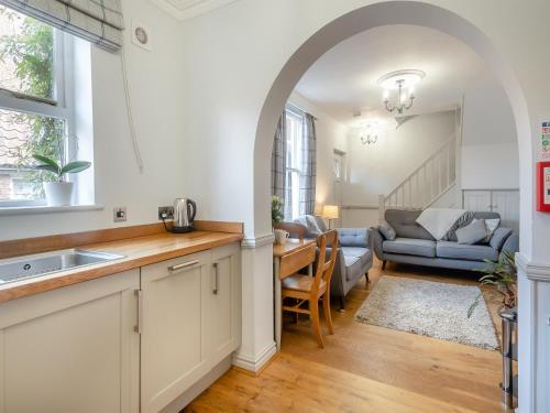 a kitchen with an archway and a living room at Hardys Cottage in Overstrand