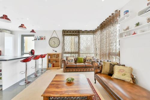 a living room with a couch and a table at Spacious, Stylish & Secure Apartment in London