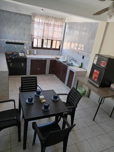 a kitchen with a table and chairs in a kitchen at Departamentos San Luis in Tarija