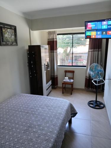 a hotel room with a bed and a flat screen tv at Departamentos San Luis in Tarija