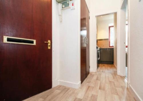 een lege hal met een deur en een houten vloer bij 21 Stafford Street (GFR) in Aberdeen
