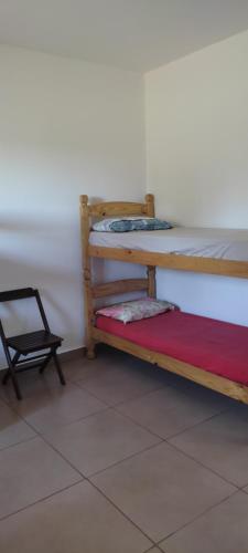 two bunk beds in a room with a chair at Pousadinha RoSi. in Santa Bárbara do Rio Pardo