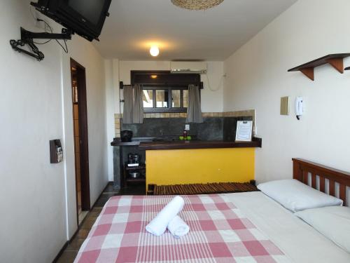 a small room with a bed and a kitchen at Apart Hotel Casa Grande in Natal