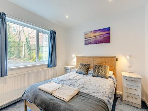 a bedroom with a bed and a window at Forest View Cottage in Nottingham