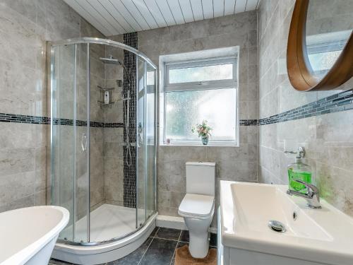 a bathroom with a shower and a toilet and a sink at Forest View Cottage in Nottingham