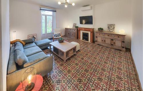 un salon avec un canapé bleu et une cheminée dans l'établissement Nice Home In Faugères, à Faugères