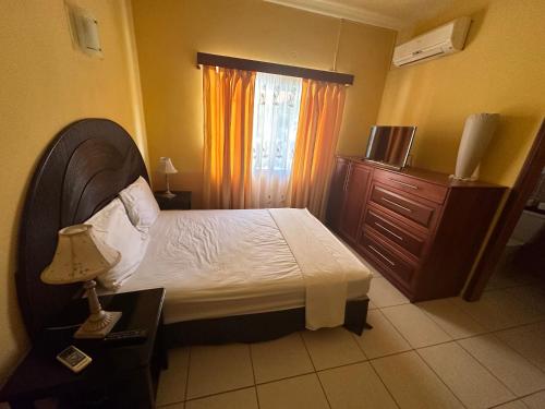 a bedroom with a bed and a dresser and a window at Little paradise in Tela