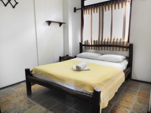a bedroom with a large bed with a yellow blanket at Apart Hotel Casa Grande in Natal